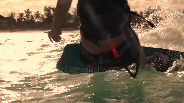 Zeitlupe Nahaufnahme: Extrem-Kiter-Mädchen Kiteboarding schnell und plantschendes Wasser — Stockvideo