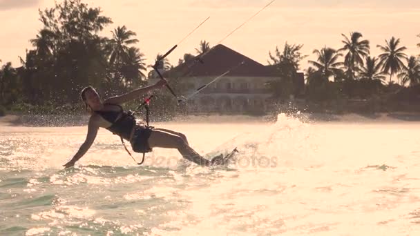Slow Motion närbild: Glada kiter flicka kiteboarding och stänkande vatten — Stockvideo