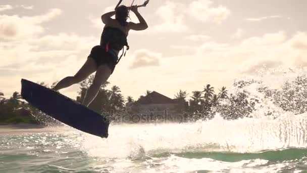 Movimiento lento CERRAR: Extremo kiter chica kiteboard salto rally truco al atardecer — Vídeo de stock