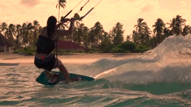 SLOW MOTION CLOSEUP : Jeune kiter woman kiteboard jumping rally at golden sunset — Video