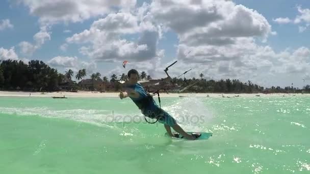 Movimiento lento: kiter kiteboarding más allá de la cámara que muestra el signo de surf shaka — Vídeos de Stock