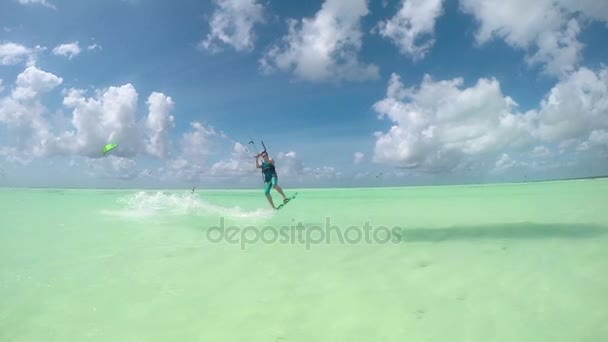 Slowmotion: Glada kite surfer hoppa högt över kameran visar shaka tecken — Stockvideo