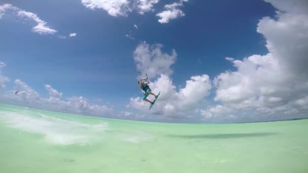 Movimiento lento: Surfista cometa extrema saltando alto sobre la cámara mostrando los pulgares hacia arriba — Vídeos de Stock
