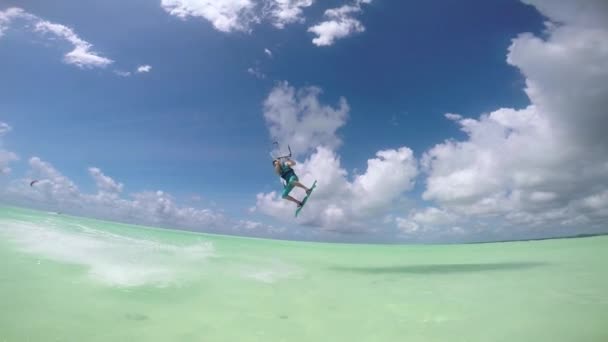 Slow Motion: Extrémní kite surfař skákání vysoké přes fotoaparát ukazuje palec — Stock video