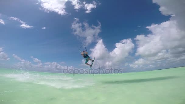 SLOW MOTION: Happy smiling kite surfer jumping over camera showing thumbs up — Stock Video