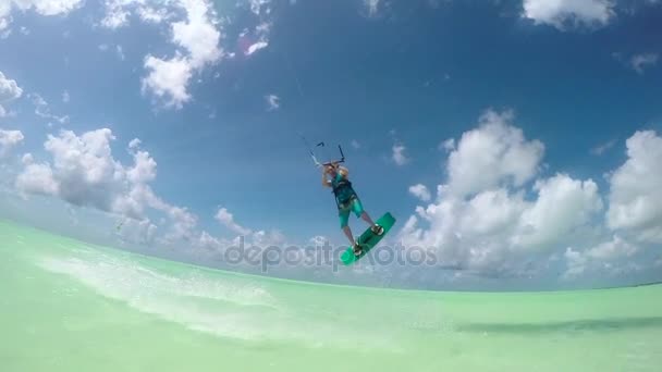 SLOW MOTION: Estremo surfista aquilone che salta in alto sopra la fotocamera mostrando segno shaka — Video Stock