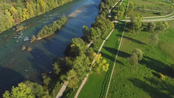 AERIAL: літати над акуратними стежками і великою річкою в зоні відпочинку парку — стокове відео