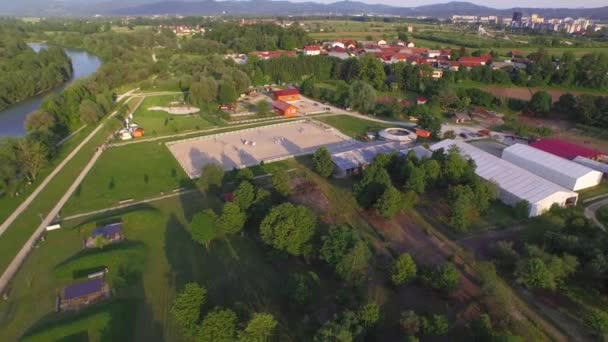 Luchtfoto: Vliegen boven paarden center, grote rivier en recreatiepark gebied — Stockvideo