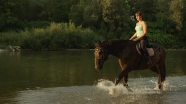 Ağır çekim: sığ nehir neşeli kız binici binicilik