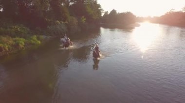 Yakın: nehre güneşli günde üç neşeli genç biniciler binicilik