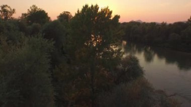Hava: küçük ada ile geniş nehir manzaralı Altın ışık günbatımında çarpıcı