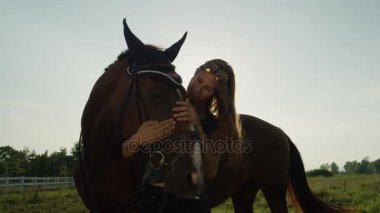Ağır çekim: Sevecen ve onun büyük kahverengi at sevişme mutlu bir kız portresi