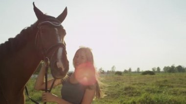 Ağır çekim: Sevişme ve öpüşme büyük kahverengi atını neşeli kız portresi