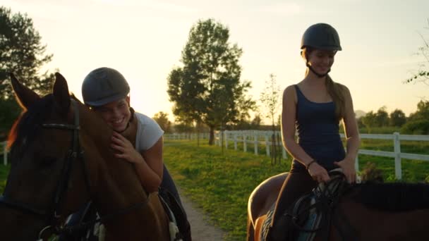 MOTION LENT : Deux jeunes filles gaies profitant d'une promenade à cheval au coucher du soleil magique — Video