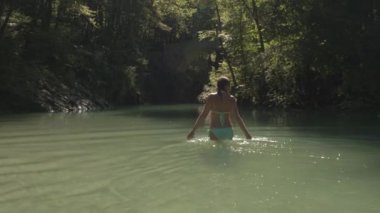 Yakın: waist yüksek nehir yürüyüş ve su sıçramasına genç mutlu kız