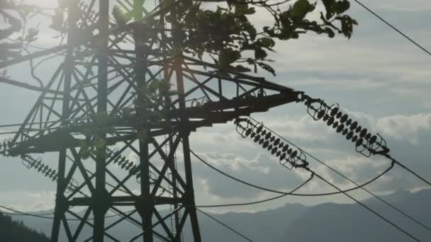 特写︰ 钢的高电压输电塔在树枝后面 — 图库视频影像