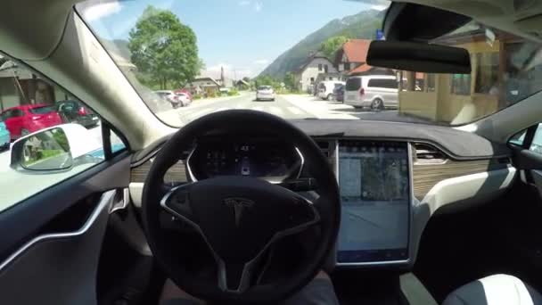 POV: Automóvel eléctrico autónomo que atravessa a aldeia rural — Vídeo de Stock