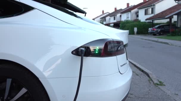 CLOSE UP: mengisi baterai mobil otonom Tesla listrik di stasiun rumah — Stok Video