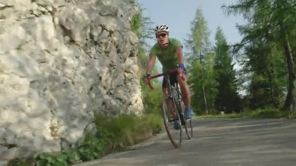 Легкий чоловік їде на своєму шосейному велосипеді по порожній асфальтній дорозі . — стокове відео