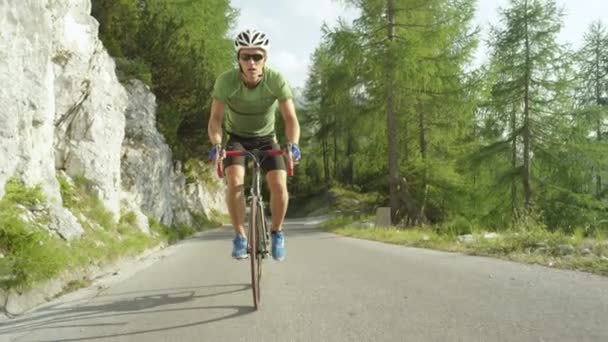 LOW ANGLE: Atletisk man utbildning för en cyclocross race i soliga bergen. — Stockvideo