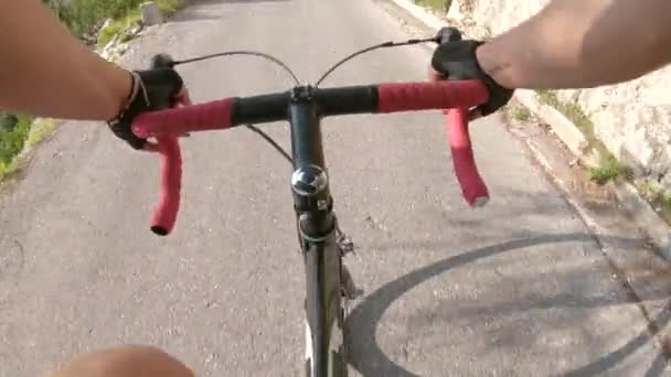 POV: Mit dem Rennrad eine steile Asphaltstraße in den sonnigen Bergen hinauf. — Stockvideo