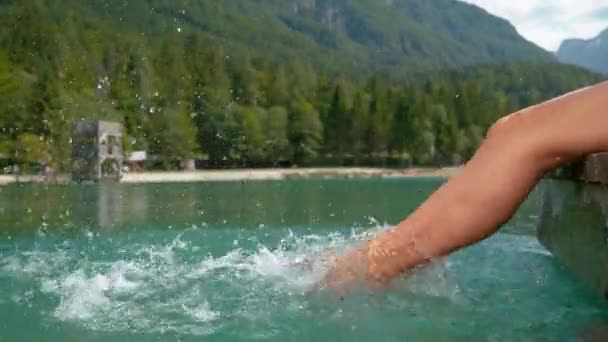 Slow Motion Effect: zorgeloze jonge vrouw spetterend water met haar blote voeten. — Stockvideo