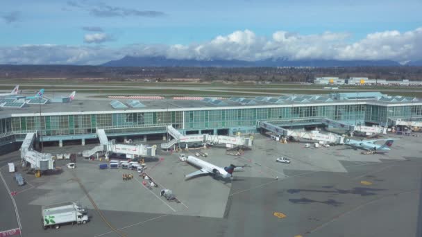 AERIAL: Flying close to the modern airport and airplanes ready for boarding. — Stock Video