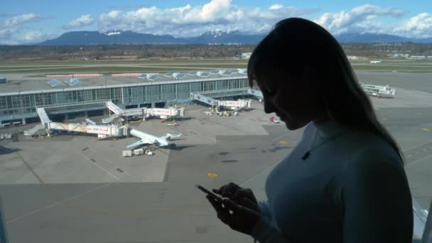 CERRAR: Mujer joven trabajando en su teléfono inteligente durante su estancia en su habitación de hotel — Vídeo de stock