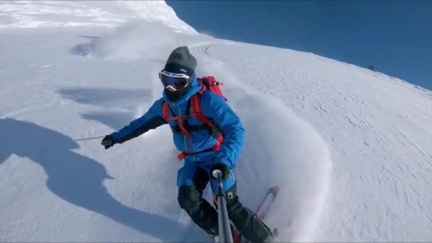 MOCIÓN LENTA: Esquiador freeride extremo tritura la nieve fuera de pista en un día soleado . — Vídeos de Stock