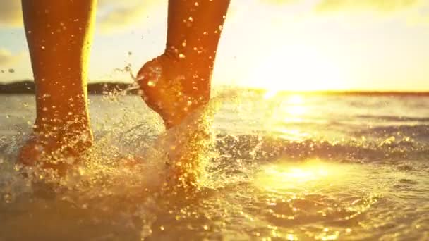 砂浜に立つ若い女性が足を濡らし清々しい海の水に浸かり — ストック動画