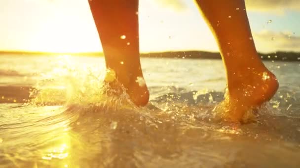 一位站在沙滩上的年轻女子在清澈的海水中擦伤了她的脚 — 图库视频影像
