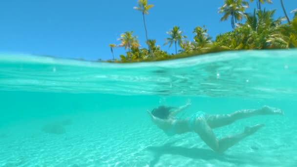 MOCIÓN LENTA: Feliz buceo turístico femenino alrededor de la paradisíaca playa de la isla . — Vídeo de stock