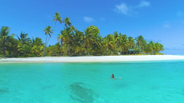 DRONE: boldog női utazó úszik a festői fehér homokos tengerparton. — Stock videók