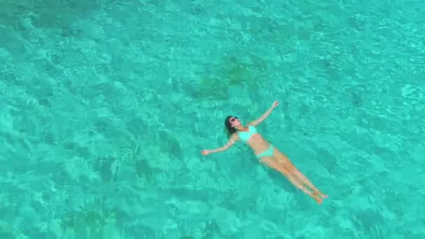 Time Warp: Ontspannen vrouw verkoelend aan het tropische strand in turquoise oceaan. — Stockvideo