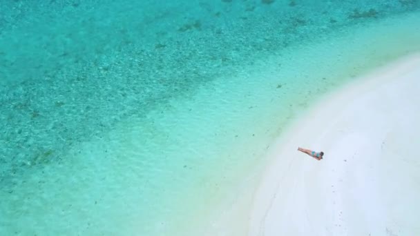 AERIAL: Flyger ovanför kvinnliga turist solbränna på den tomma tropiska stranden. — Stockvideo