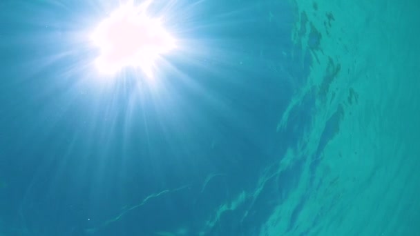 SOTTO ACQUA: raggi di sole accecanti e luminosi che brillano attraverso la calma superficie dell'oceano . — Video Stock
