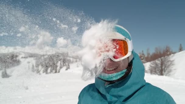 LOW MOTION: Garota excitada vestindo óculos de esqui é atingido na cabeça por bola de neve . — Vídeo de Stock