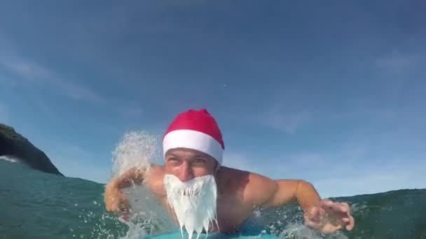 SLOW MOTION CLOSE UP: Cheerful uoung Santa Clause surfing fun waves in an ocean — Stock Video