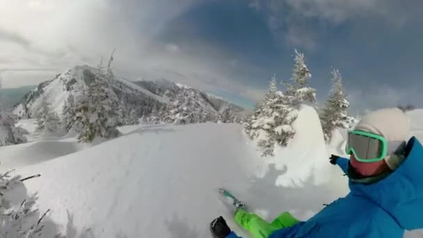 SELFIE: Male tourist snowboarding off trail and carving between spruce trees. — Stock Video