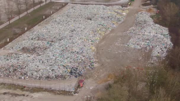 AERIAL: Rodeando grandes montones de basura amontonándose en un remoto vertedero . — Vídeos de Stock