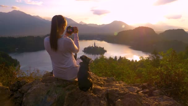 CLOSE UP: Unrecognizable female traveler sitting on a rock and taking photos. — 비디오