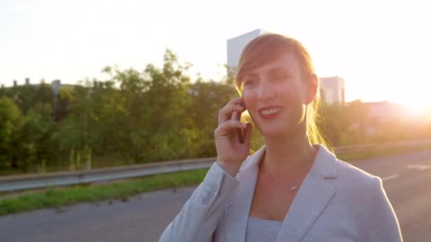 CLOSE UP: Stilvolle Geschäftsfrau telefoniert beim Gehen auf dem Bürgersteig — Stockvideo