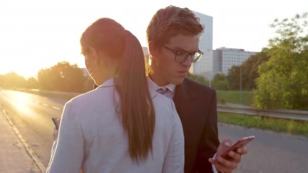 Lente FLARE: Hombre guapo caminando al trabajo y mensajes de texto se estrella en la mujer de negocios . — Vídeos de Stock