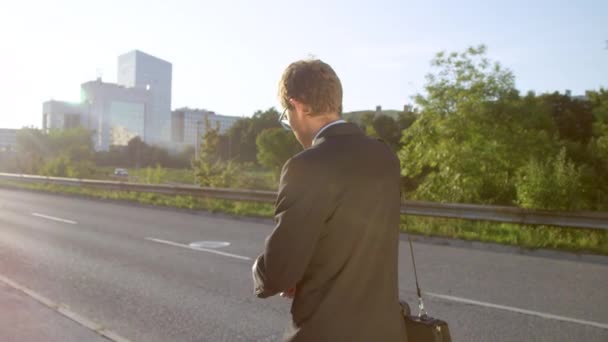 Slow Motion: Ung affärsman kollar klockan och får reda på att han är sen till jobbet. — Stockvideo