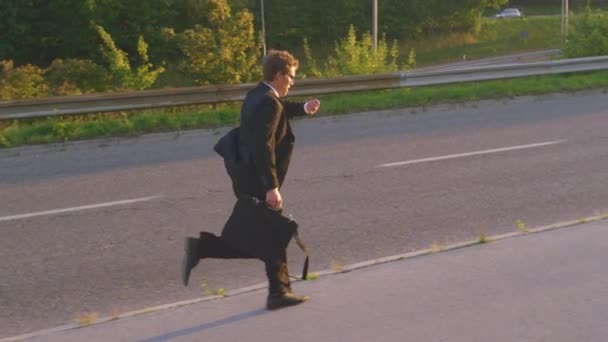 SUN FLARE: Young man in suit and tie sprinting to his office on a sunny morning. — Stock Video