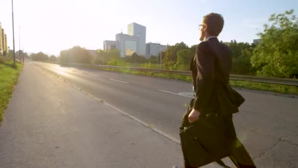 LENS FLARE: Oigenkännlig affärsman som springer till jobbet en solig vårmorgon — Stockvideo