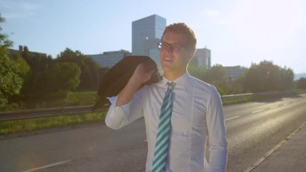 PORTRAIT: Carefree businessman casually walking down the street on a sunny day. — Stock Video