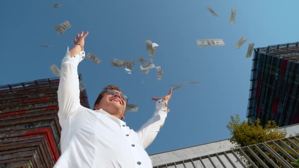 Bottom Up: Rijke bankier glimlacht terwijl het gooien van honderd dollar biljetten in de lucht. — Stockvideo