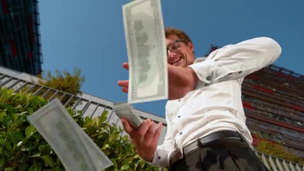 Efekt Slow Motion: Szczęśliwy biznesmen rzucający w powietrze banknotami za sto dolarów. — Wideo stockowe