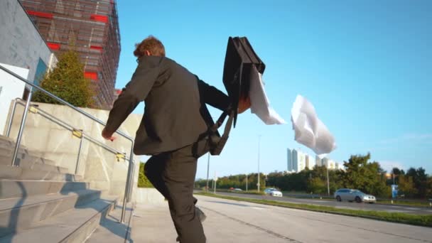 Podnikatel chodí pozdě do práce a ztrácí důležité papíry.. — Stock video